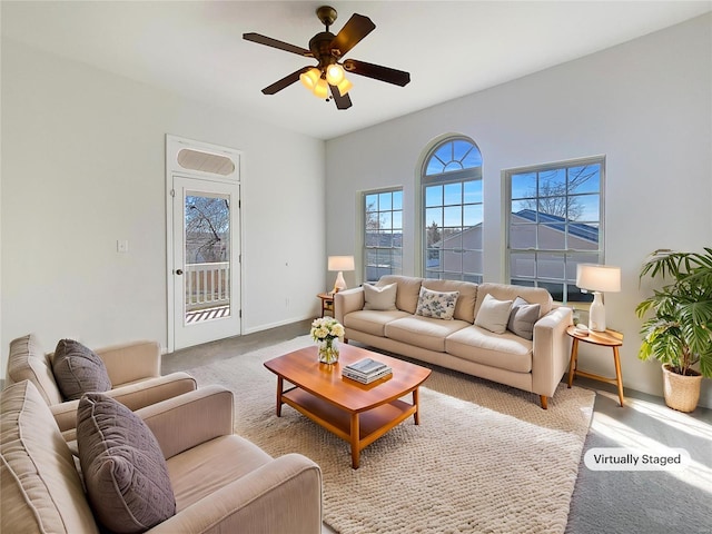 living room with baseboards, carpet floors, and ceiling fan