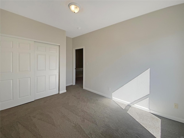 unfurnished bedroom featuring carpet, baseboards, and a closet