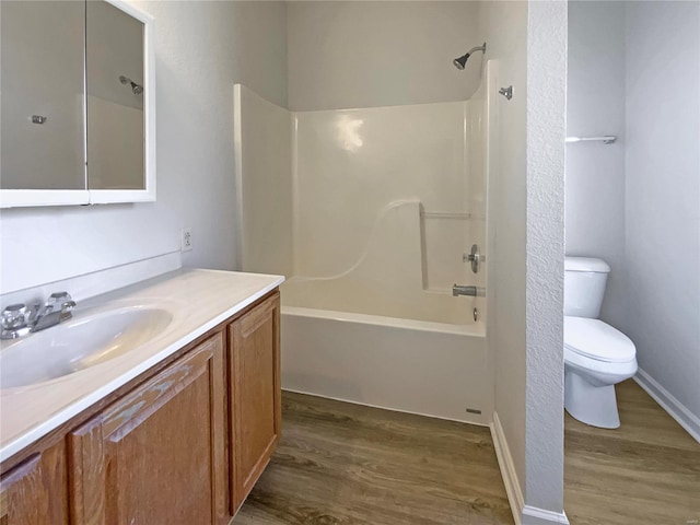 bathroom featuring tub / shower combination, toilet, wood finished floors, and vanity