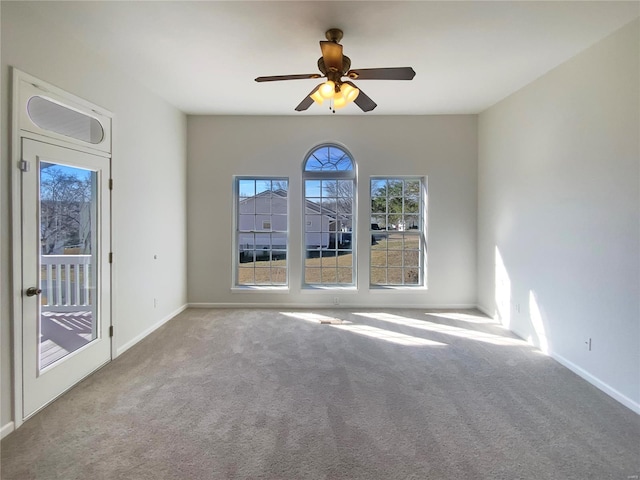 spare room with baseboards, carpet floors, and ceiling fan