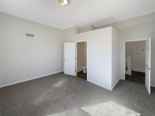 unfurnished bedroom featuring visible vents, baseboards, carpet, and ensuite bath