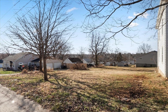 view of yard with a garage and a residential view