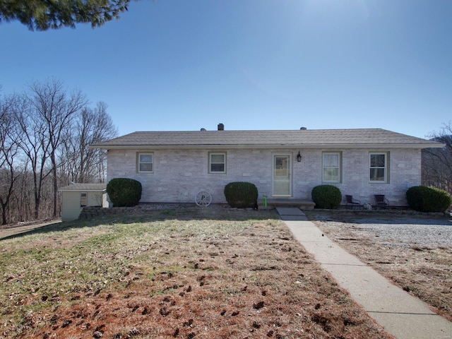 single story home with brick siding and a front yard