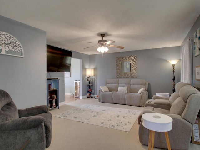 living area with light colored carpet, baseboards, and ceiling fan