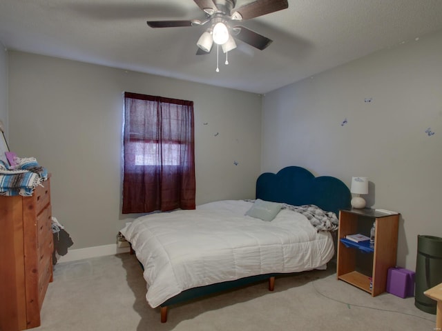 carpeted bedroom featuring a ceiling fan and baseboards