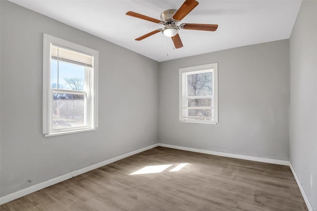 unfurnished room with a ceiling fan, baseboards, and wood finished floors