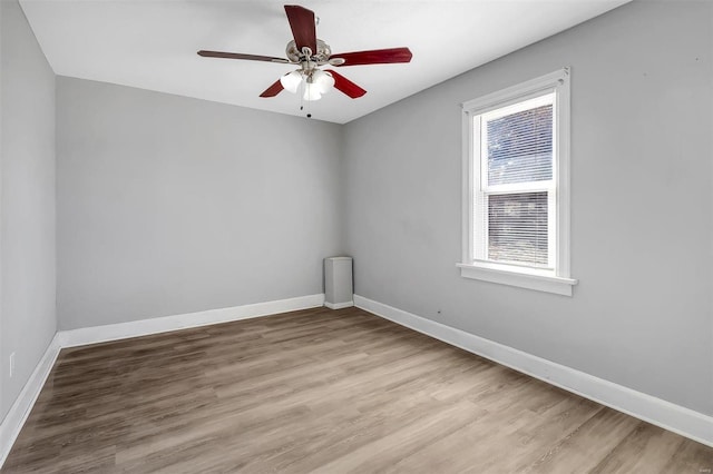 unfurnished room featuring a ceiling fan, baseboards, and wood finished floors