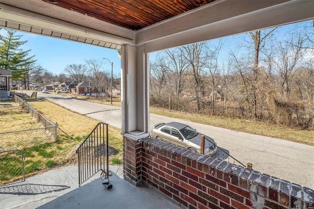 view of patio featuring a porch and fence