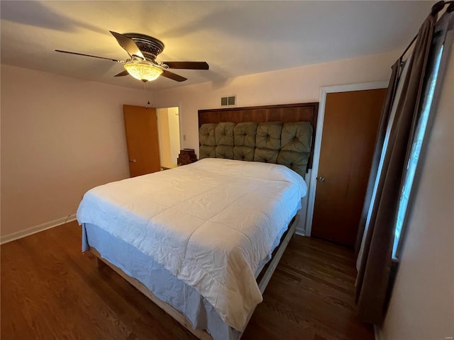 bedroom with ceiling fan, visible vents, baseboards, and wood finished floors