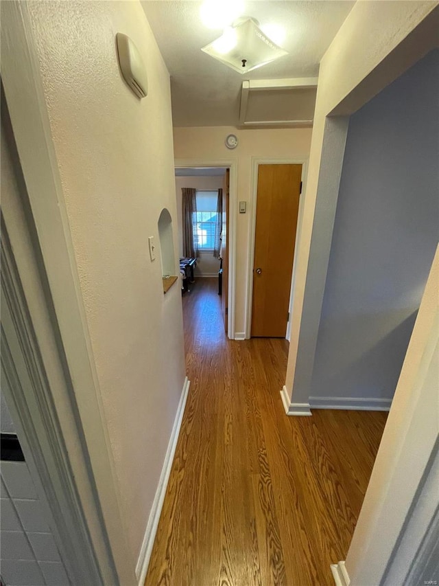 hall featuring baseboards and wood finished floors