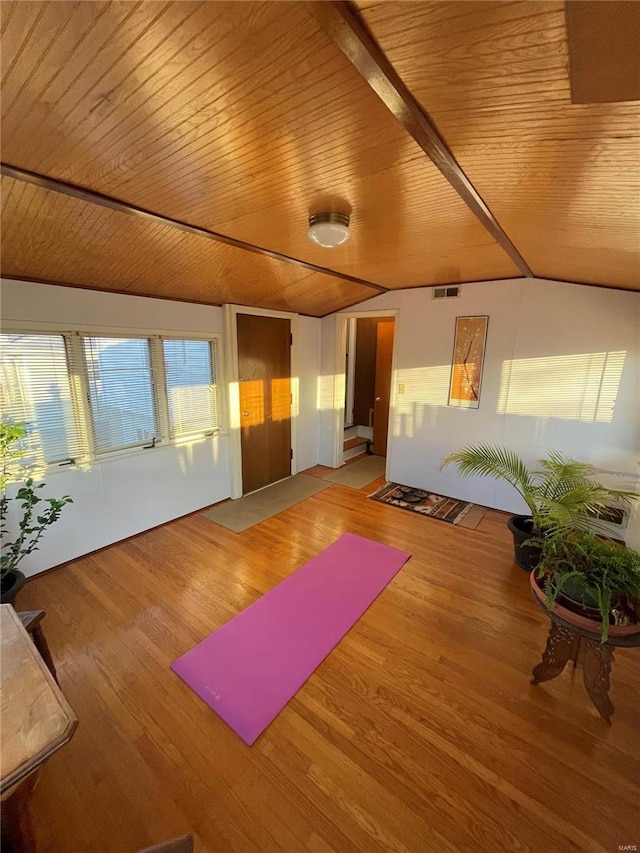 exercise room with vaulted ceiling, wood ceiling, visible vents, and wood finished floors