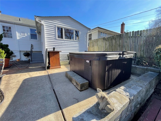 view of patio / terrace featuring fence and a hot tub