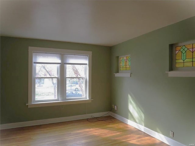 unfurnished room featuring baseboards and wood finished floors