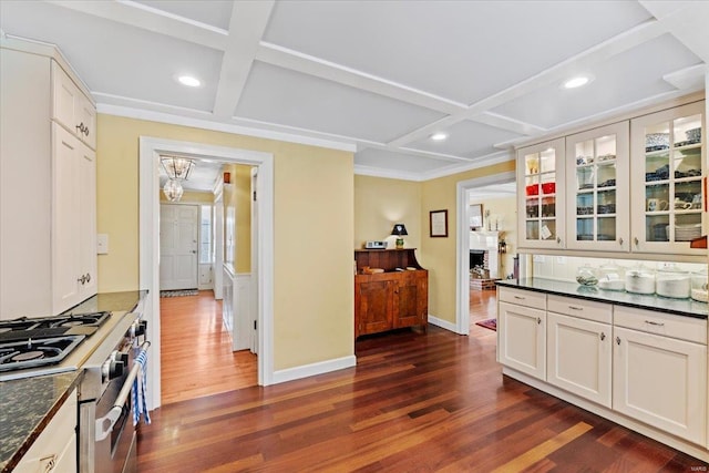 kitchen with glass insert cabinets, gas range, coffered ceiling, and dark wood finished floors