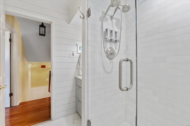 full bathroom featuring wainscoting, a shower stall, and marble finish floor