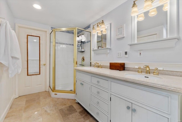 full bath with a sink, a stall shower, and double vanity