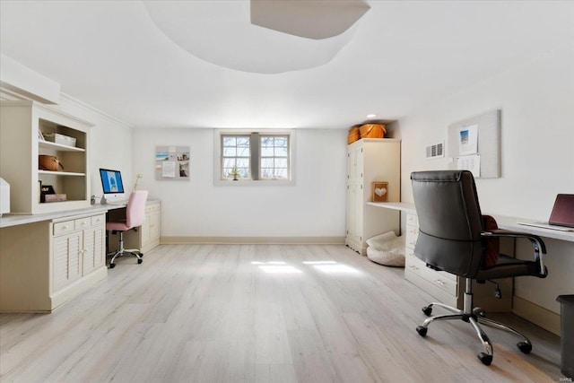 office space featuring built in desk, light wood-style flooring, baseboards, and visible vents