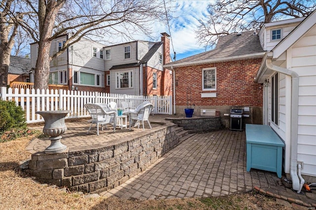 view of patio with area for grilling and fence