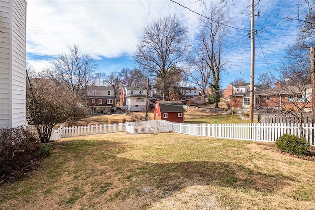 view of yard with a residential view, an outbuilding, and a fenced backyard