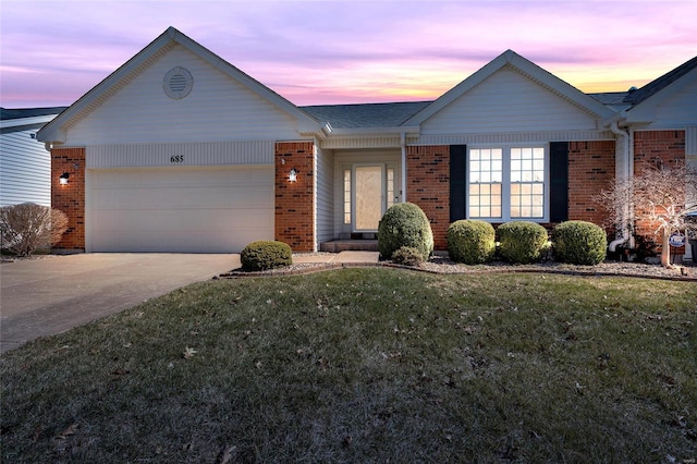 ranch-style house featuring brick siding, a lawn, an attached garage, and concrete driveway