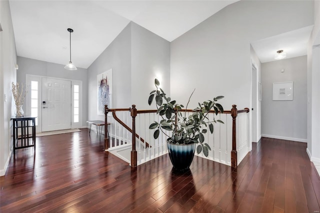 entryway with high vaulted ceiling, baseboards, and wood finished floors