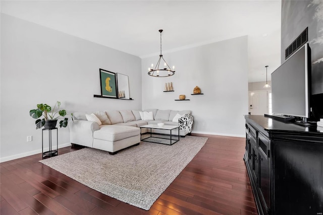 living area featuring a chandelier, visible vents, dark wood-type flooring, and baseboards