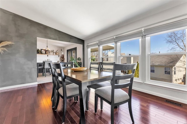 dining space with visible vents, an inviting chandelier, dark wood-style flooring, and vaulted ceiling