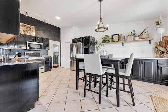 dining area featuring a notable chandelier and light tile patterned flooring