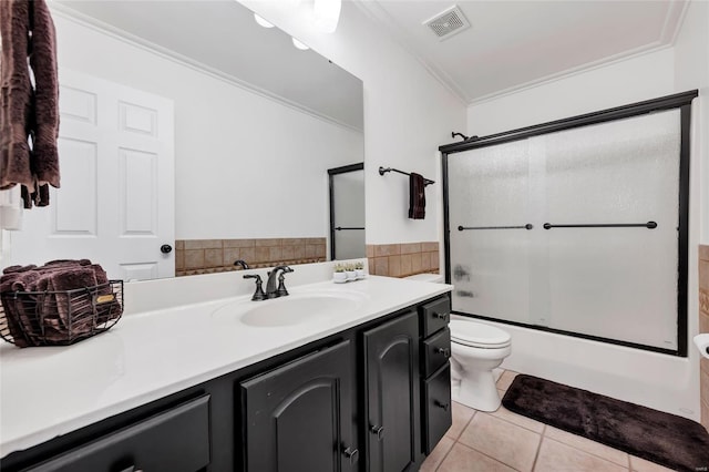 full bathroom with vanity, ornamental molding, tile patterned flooring, toilet, and combined bath / shower with glass door