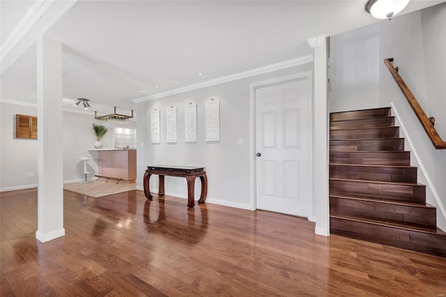 foyer with stairs, crown molding, baseboards, and wood finished floors