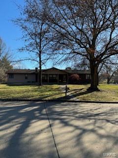 ranch-style house with driveway and a front yard