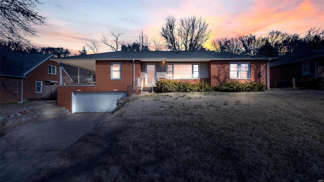 ranch-style home featuring brick siding, an attached garage, and driveway