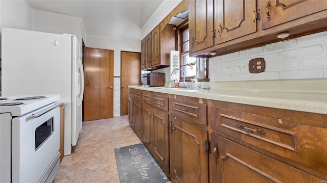 kitchen with a sink, brown cabinets, light countertops, and electric stove