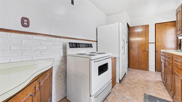 kitchen with white appliances, light countertops, brown cabinets, and wainscoting