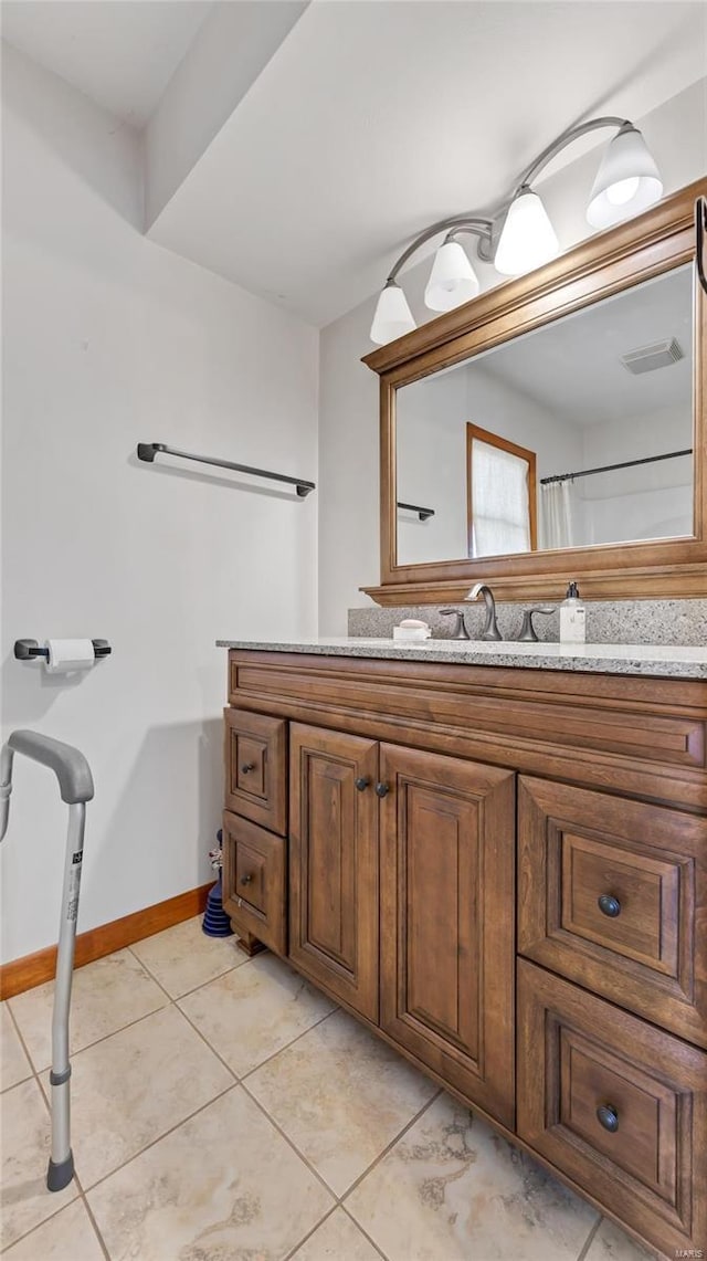 bathroom with tile patterned floors, baseboards, and vanity