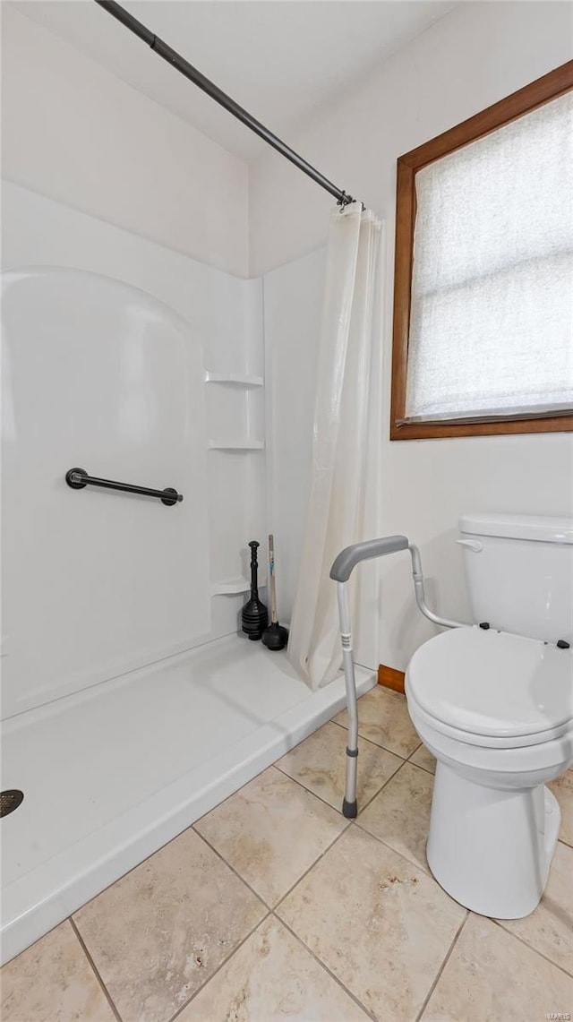 bathroom featuring tile patterned floors, baseboards, toilet, and a shower with curtain