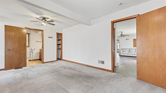 unfurnished bedroom with visible vents, beamed ceiling, ensuite bath, carpet, and baseboards