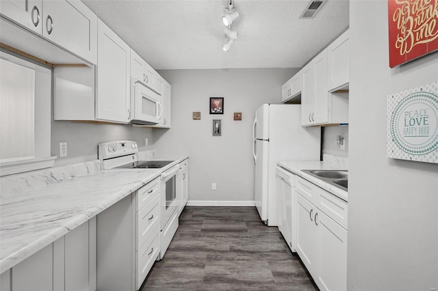 kitchen featuring visible vents, a sink, a textured ceiling, white appliances, and white cabinets