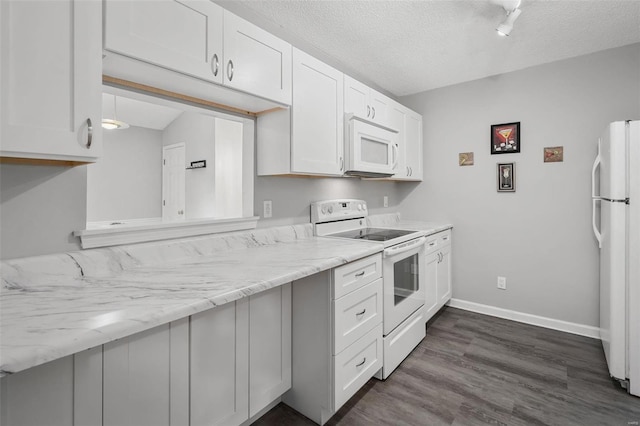 kitchen with baseboards, dark wood finished floors, a textured ceiling, white appliances, and white cabinetry