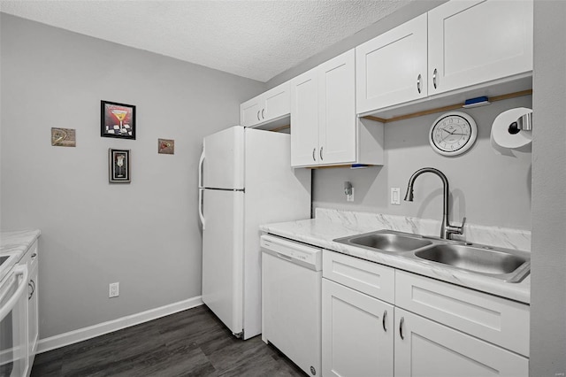 kitchen with a sink, white appliances, white cabinets, and light countertops