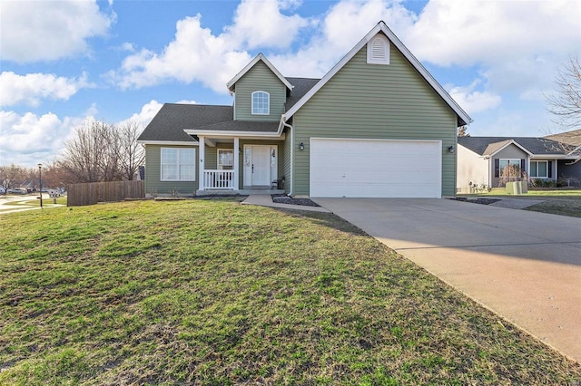 traditional-style house with a porch, fence, concrete driveway, an attached garage, and a front yard