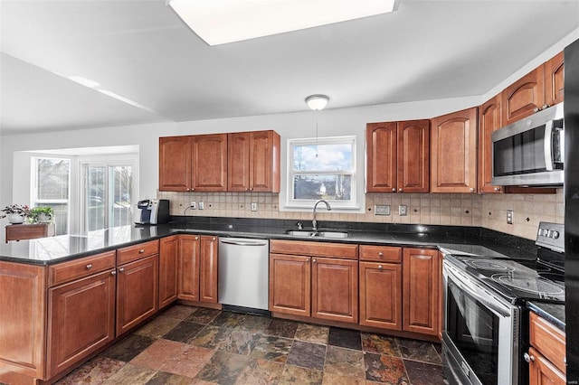 kitchen with a sink, a healthy amount of sunlight, tasteful backsplash, and stainless steel appliances