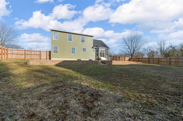 rear view of property with a lawn and a fenced backyard