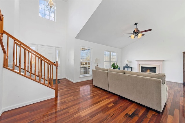 living room featuring stairway, plenty of natural light, a glass covered fireplace, and hardwood / wood-style flooring