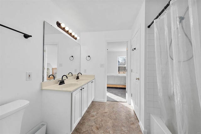 ensuite bathroom with ensuite bath, double vanity, toilet, and a sink