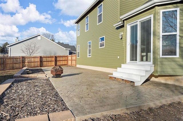 exterior space featuring entry steps, an outdoor fire pit, a patio, and fence