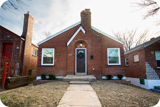 view of front of house featuring brick siding and a chimney