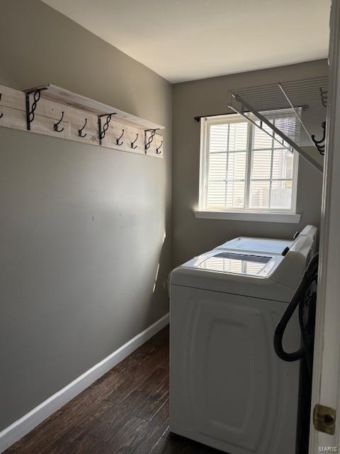 laundry room with laundry area, washing machine and dryer, baseboards, and dark wood-style flooring