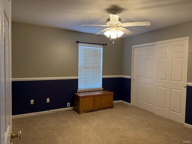 unfurnished bedroom featuring a closet, carpet flooring, a ceiling fan, and baseboards