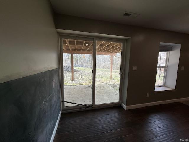 doorway to outside with visible vents, dark wood-type flooring, and baseboards